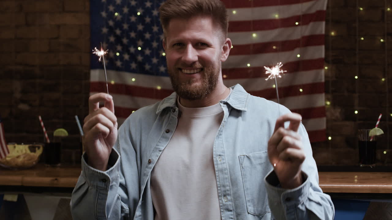 Man celebrating with sparklers in front of American flag