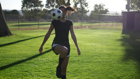 Eine-Junge-Fußballspielerin,-Die-Während-Einer-Teamfrauen-Sportpraxis-Einen-Fußball-Jongliert-Und-Tritt