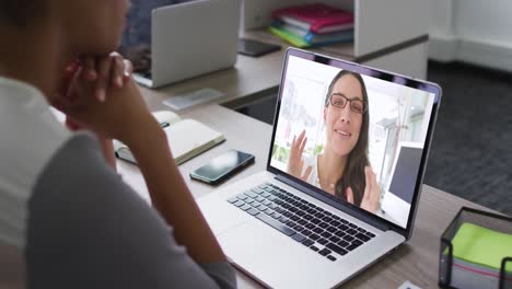 African-american-woman-having-a-video-conference-on-laptop-with-female-office-colleague-at-office