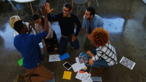 equipo de ejecutivos dando cinco altos el uno al otro en la reunión