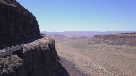 Cliff-aerial:-Road-carved-into-rock-wall-of-Frenchman-Coulee,-WA-state