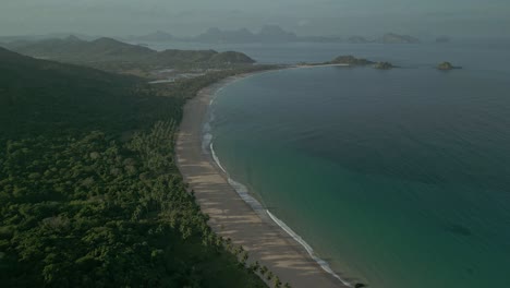 Wide-aerial-pull-out-of-secluded-beach,-sea-and-forest-in-Philippines