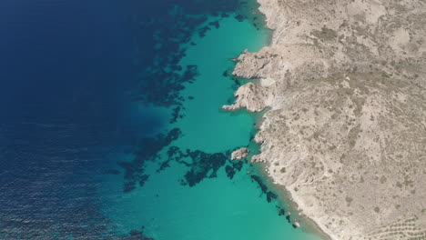 Amplia-Vista-Aérea-De-Arriba-Hacia-Abajo-De-La-Costa-De-La-Isla-Griega-En-Milos-En-Verano-Con-El-Mar-Egeo-Azul-Turquesa