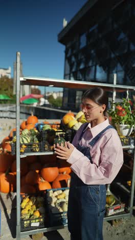mujer mirando calabazas en un mercado de agricultores