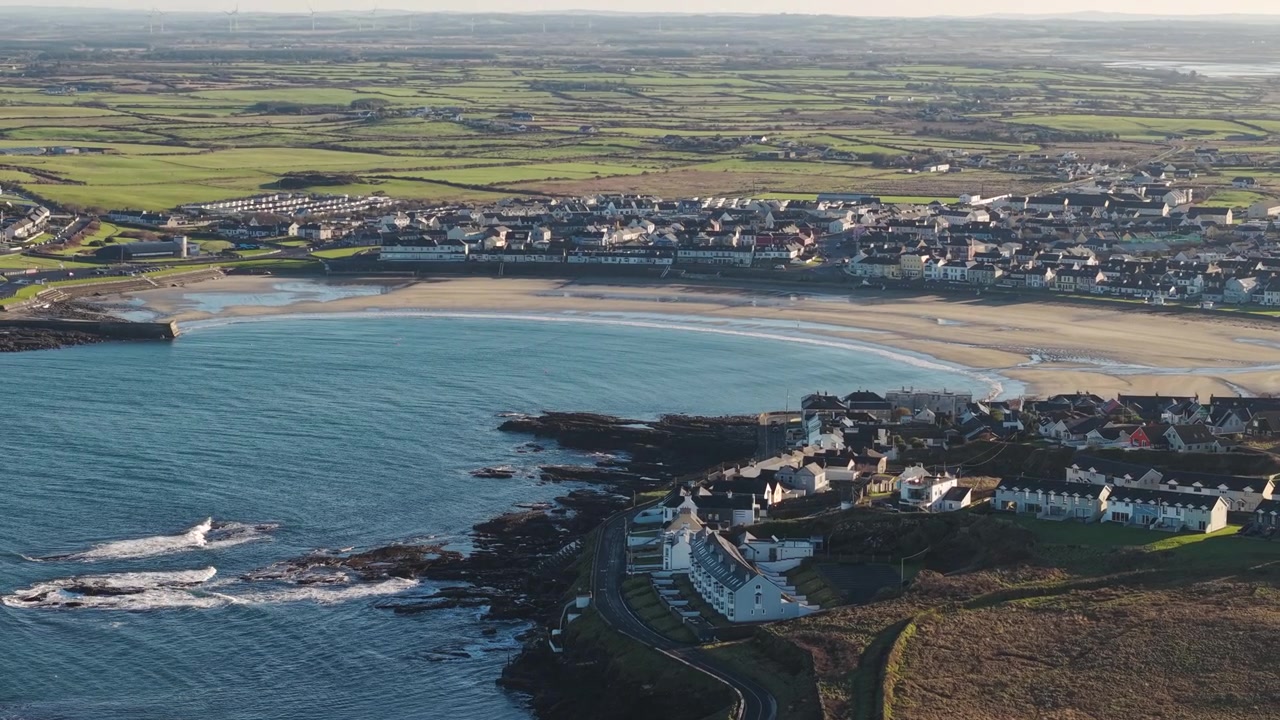 Kilkee, Irlanti. Yleiskuva dronella kaupungin rakennuksista ja rannasta lahdessa aurinkoisena aamuna.
