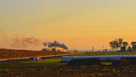 a steam passenger train approaching with a full head of steam at sunrise during the golden hour