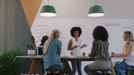 diverse business women meeting in boardroom brainstorming team manager presenting creative ideas for project using financial graph data in office workplace presentation