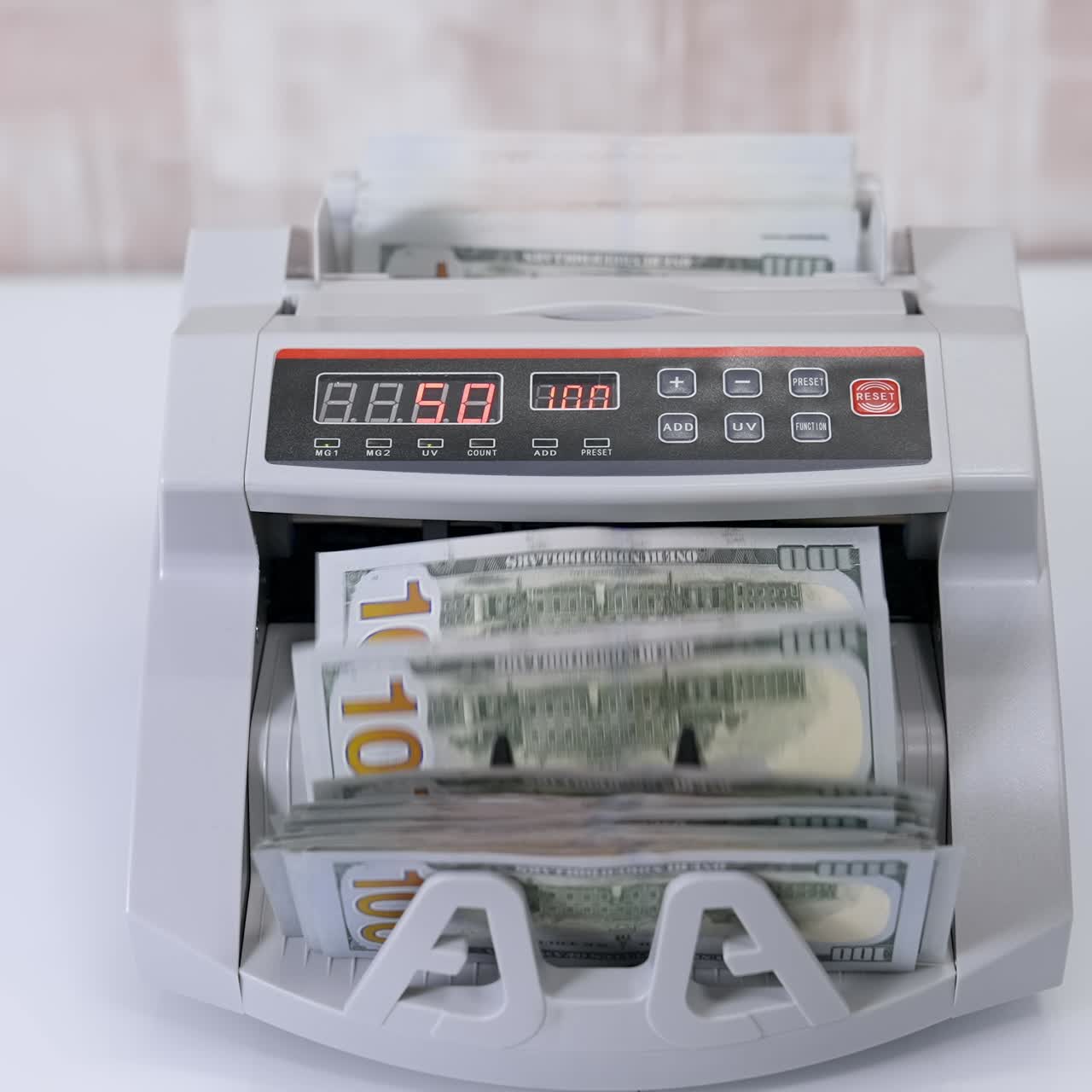 USD on money counting machine. Woman putting money into counting machine