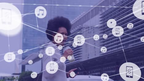 Animation-of-network-of-connections-with-icons-over-african-american-woman-crossing-street-in-city