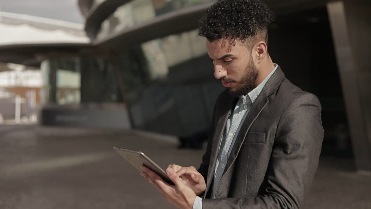 hombre de negocios enfocado trabajando con tablets al aire libre