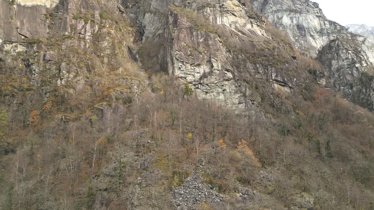 las formaciones rocosas grises están cubiertas de árboles sin hojas, las laderas rocosas están rodeadas de hierba amarilla, cavergno, vallemaggia, suiza