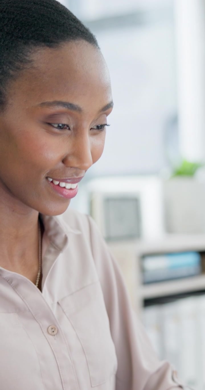 Una donna professionista sorridente che lavora al portatile in ufficio