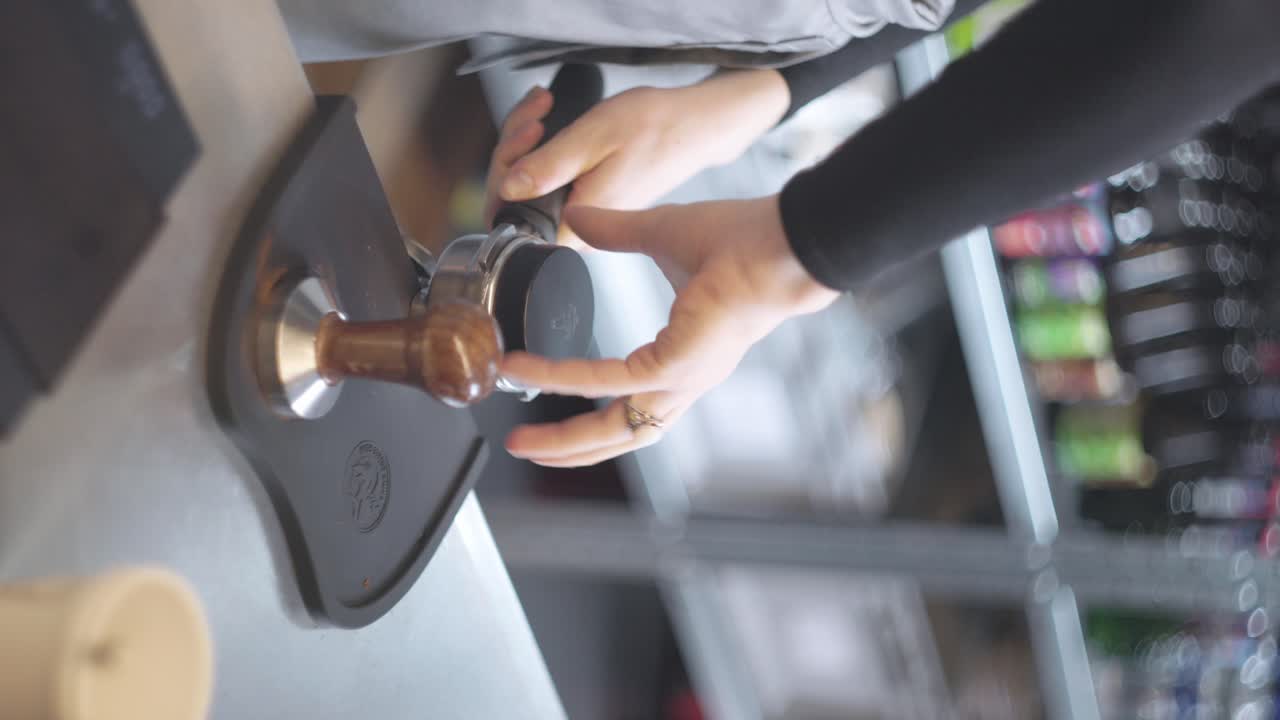 Vertical, Person grabs coffee portafilter basket prepared it and screws on lid