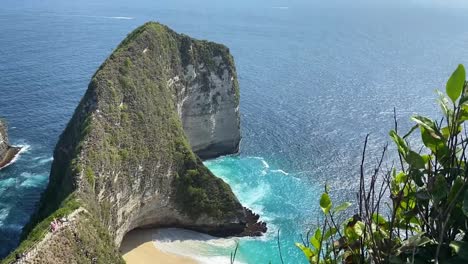 sweeping view of kelingking beach with dramatic cliffs and turquoise waters, nusa penida island, tilt up along ridge