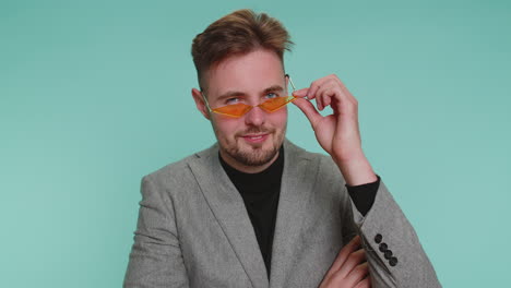happy business man wearing sunglasses blinking eye looking at camera with smile winking flirting