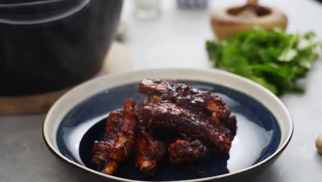 crop person putting fried ribs on plate