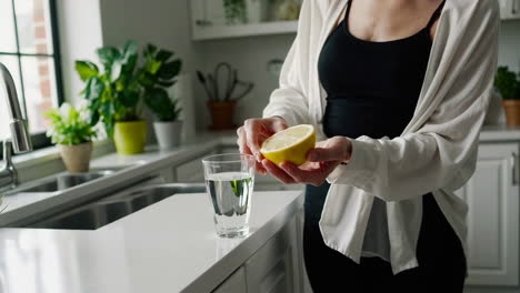woman preparing lemon water in the kitchen