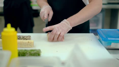 cook cuts a japanese roll with bacon