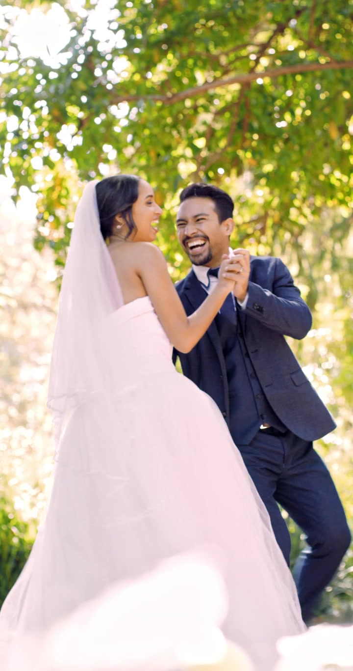 Pareja de recién casados feliz bailando juntos en un jardín