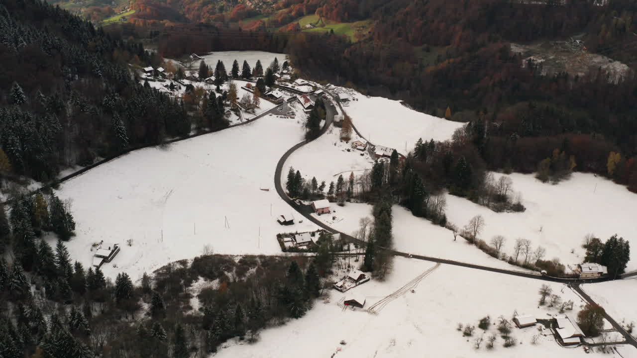 antena de un pequeño pueblo en invierno con vistas a un valle verde