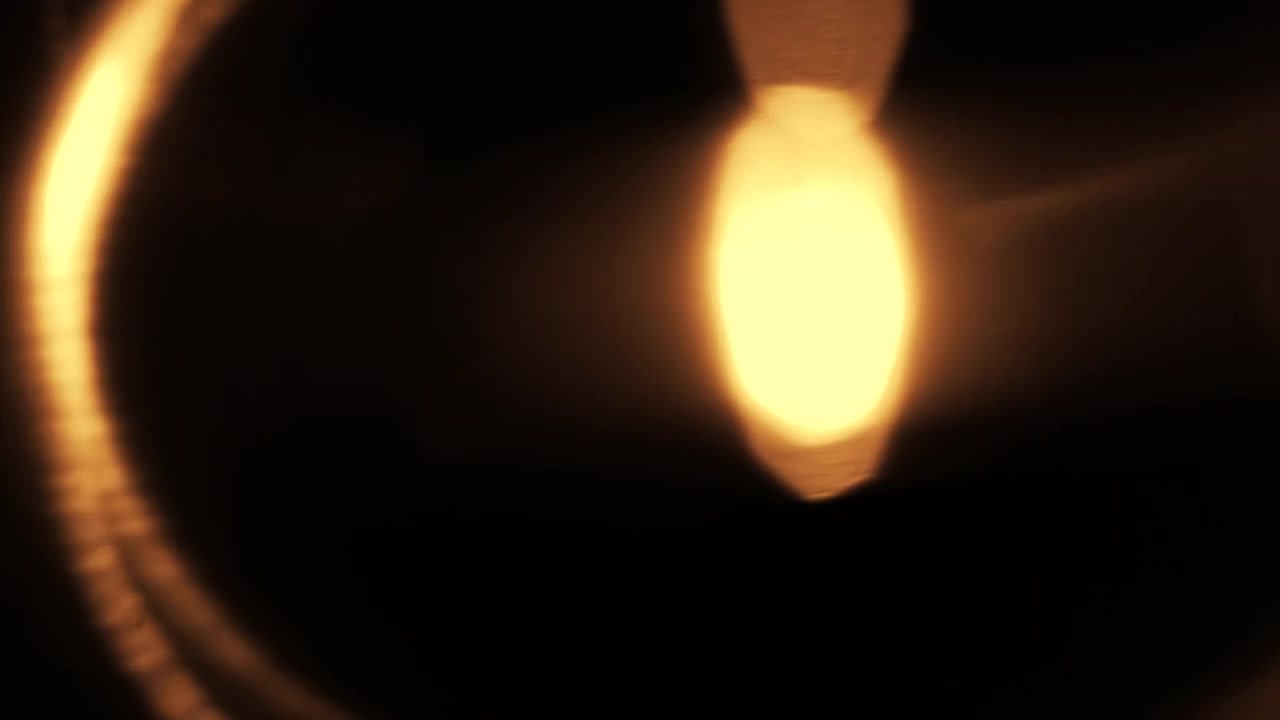 Fughe di luce dorate astratte e bagliori dell'obiettivo su sfondo nero
