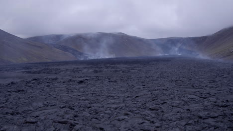 volcán fagradalsfjall en islandia tiro aéreo bajo empuje en tiro por encima de los campos de lava enfriamiento