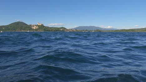 surface level view of small boat sailing on maggiore lake in italy