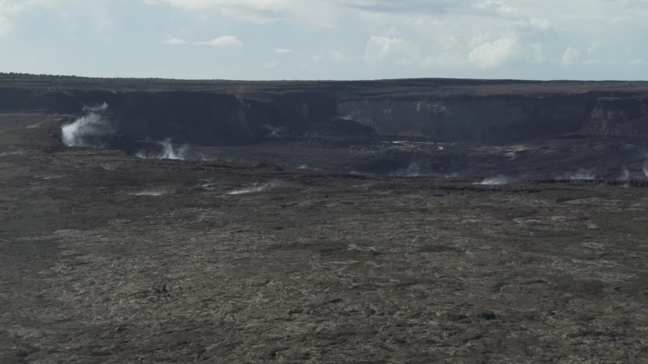 hacia abajo a la parte superior de un cráter de volcán negro oscuro con vapor y humo que se eleva desde el suelo