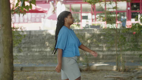 Toma-De-Seguimiento-De-Una-Mujer-Con-Sobrepeso-Caminando-Por-Un-Sendero-En-La-Ciudad