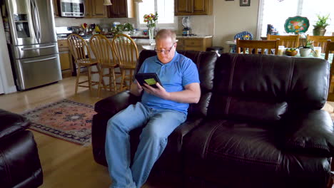 a man uses a tablet to search the internet, read, shop, work or do email