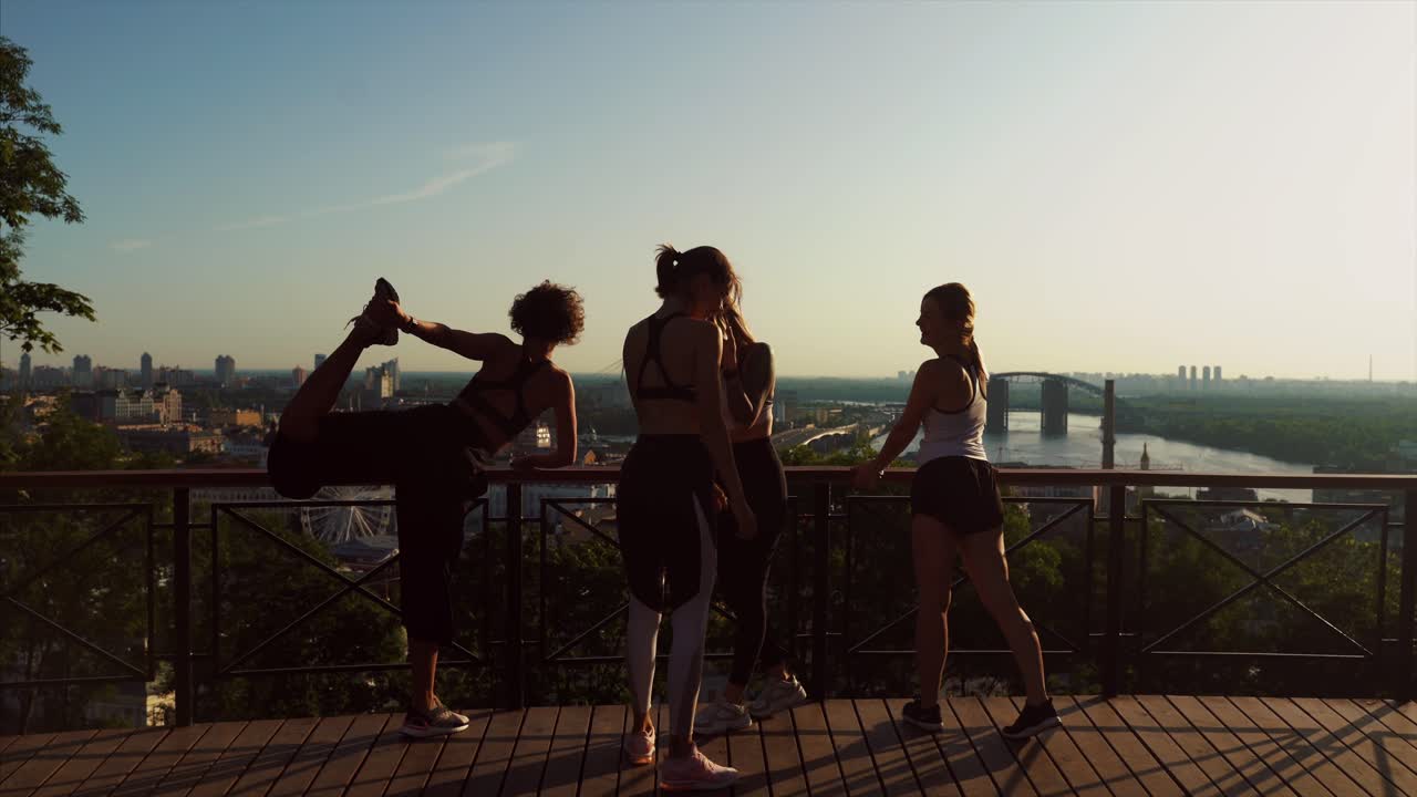 amigos estirándose al aire libre con vistas a la ciudad