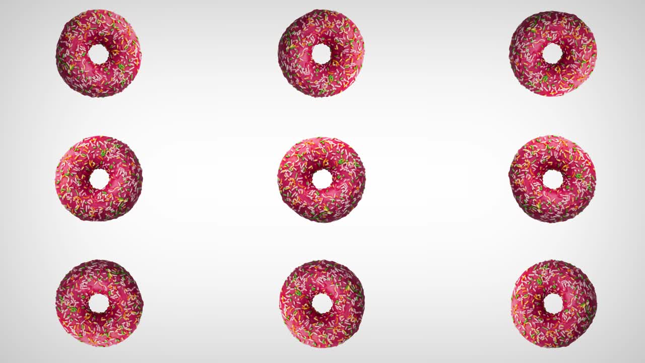 Abstract rotation of donuts with colorful sprinkles on white background.
