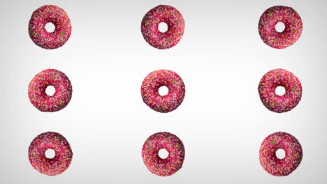 abstract rotation of donuts with colorful sprinkles on white background.