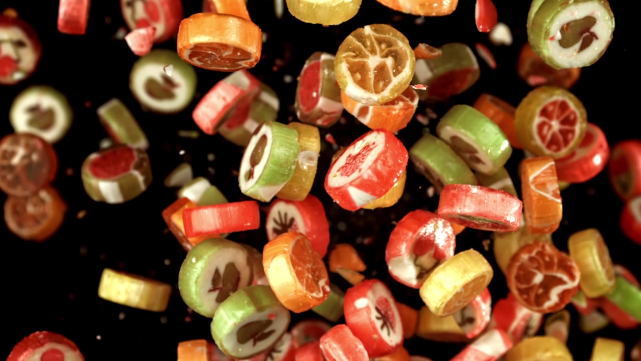 Bunte Fruchtbonbons fallen in Zeitlupe