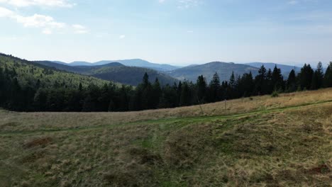 Mountain-peaks-landscape-during-a-summer-day-with-mountains-peaks,-forest,-lush-greenery-and-trees