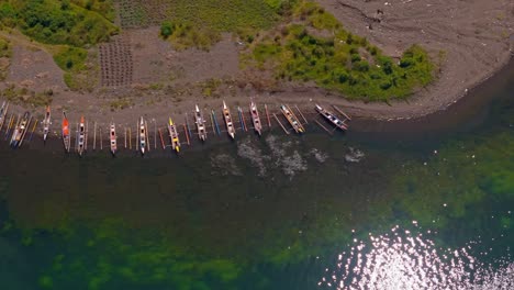 long row of fishing kayaks docked along lake mainit shoreline