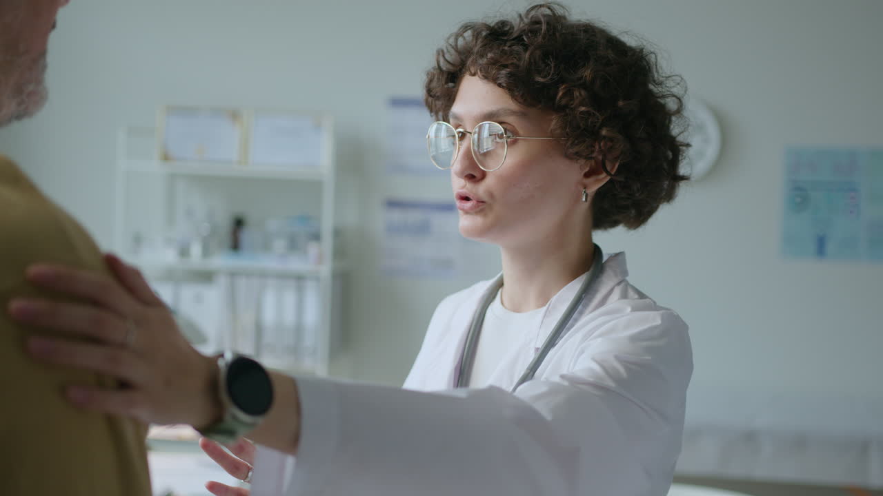 Attentive Female Doctor Supporting Patient during Treatment in Clinic