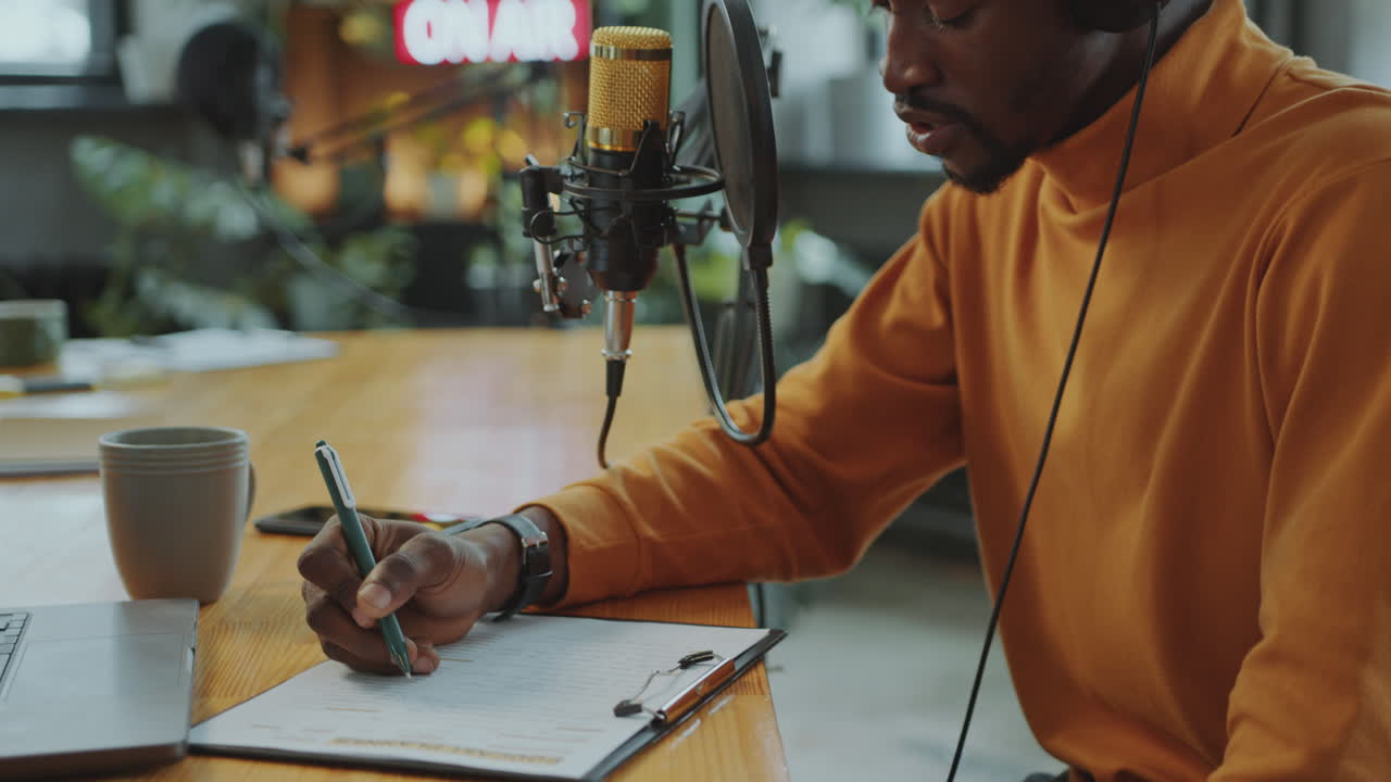 blogger masculino grabando podcast de audio y tomando notas en papel