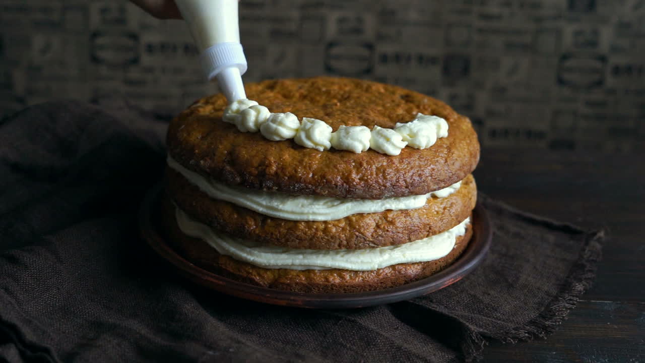 chef decorando pastel con crema. decoración de pastel de crema. chef usando bolsa de pastelería