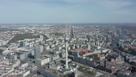 AERIAL:-Super-Close-Up-View-of-the-Alexanderplatz-TV-Tower-in-Berlin,-Germany-on-hot-summer-day