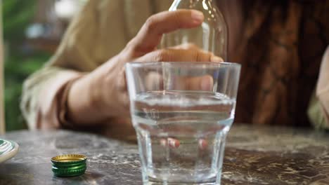 mujer vertiendo agua en un vaso en una cafetería
