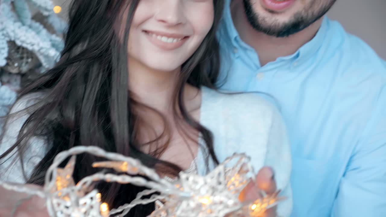 Pareja sosteniendo luces de Navidad