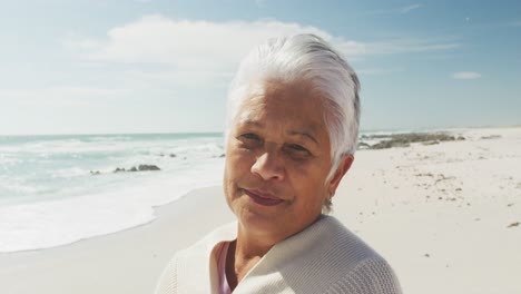 Porträt-Einer-älteren-Hispanischen-Frau,-Die-Am-Strand-Steht-Und-In-Die-Kamera-Lächelt