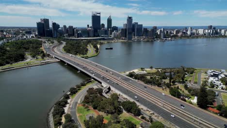 vista aérea cinematográfica de la autopista narrows bridge en el río swan con la vista de la ciudad de perth famosos edificios del horizonte en el fondo, perth, australia occidental