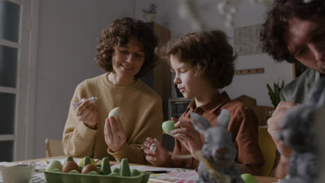 la familia decora el huevo de pascua.