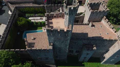 aerial revealing shot of chateau de pouzilhac with a tower and private pool