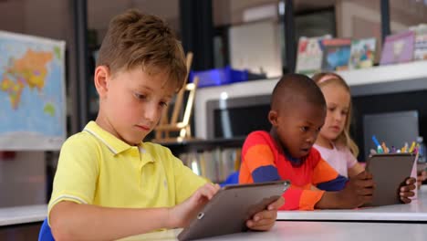 front view of caucasian schoolboy using digital tablet in the classroom 4k