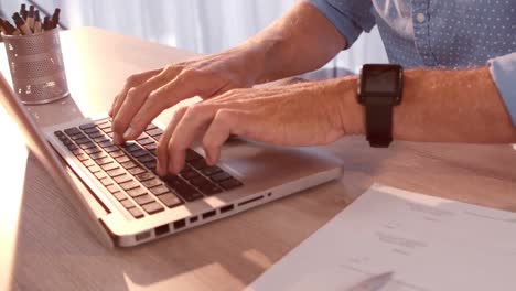 Businessman-working-on-laptop-in-office