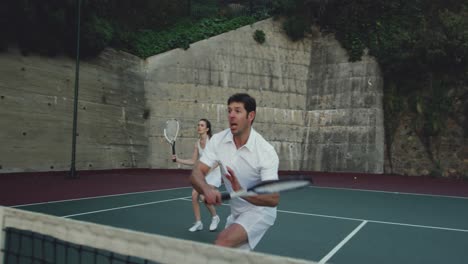 Woman-and-man-playing-tennis-on-a-court