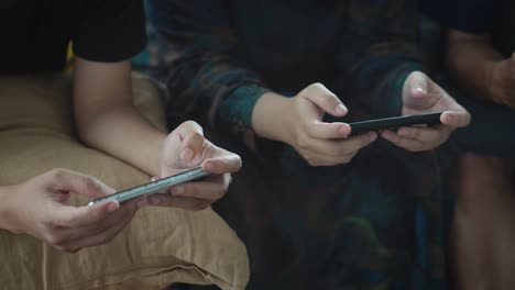 hands of young people using smartphone and playing games online together